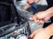 A Man Applying STEK Clear Bra To Black Car that looks like Plastic Wrap after Paintless Dent Repair Service