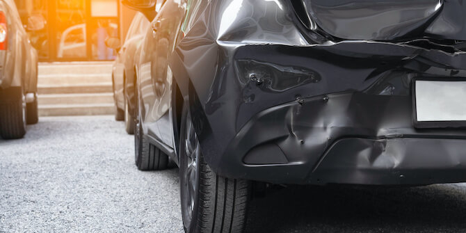 How Paintless Dent Repair Works Damaged Rear End Bumper Of Black Car from Car Accident Needs Paintless Dent Repair Service