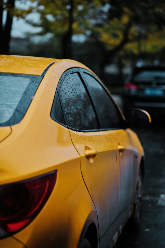 Yellow car getting rained on