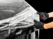 3M Ceramic Coating on a black car being pulled on to the hood of car by technician