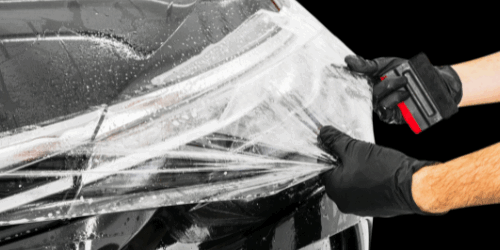 3M Ceramic Coating on a black car being pulled on to the hood of car by technician